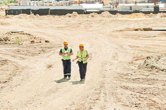 A man and woman in protective gear at a construction site.