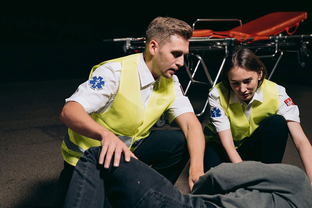 Two paramedics helping someone after a ZF Transmissions manufacturing workplace injury took place
