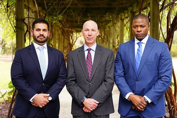 Three lawyers standing together outside who work for a SC premises liability law firm