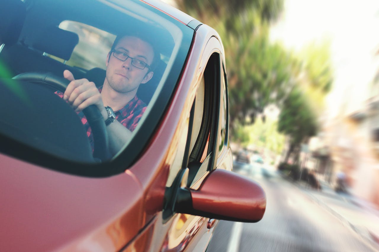 A person driving in a new red vehicle after receiving a car accident settlement in Berkeley County, SC