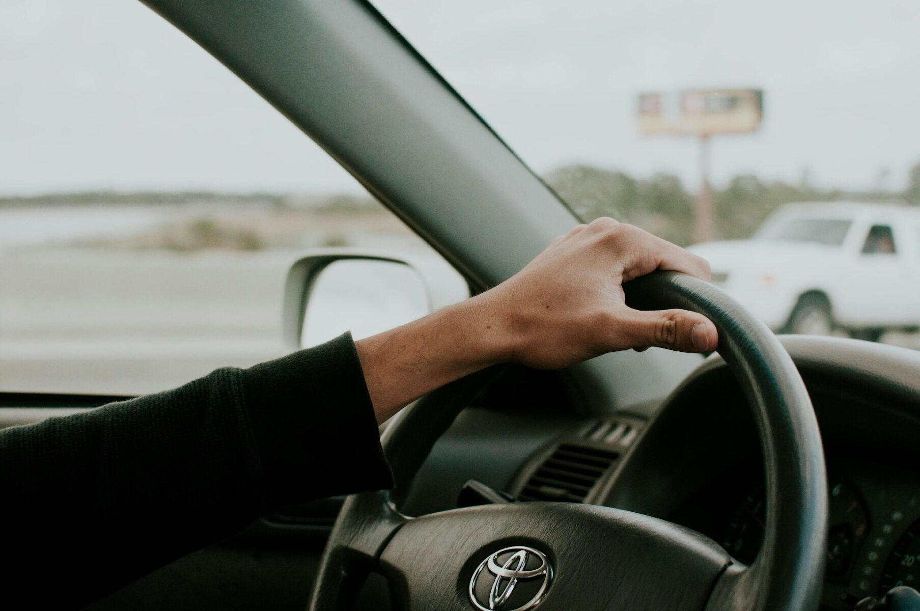A person’s hand on a steering wheel as they drive
