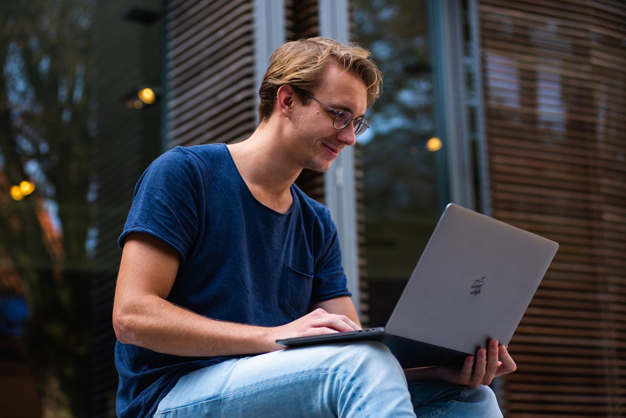 A person smiling while using a laptop to access a resource hub