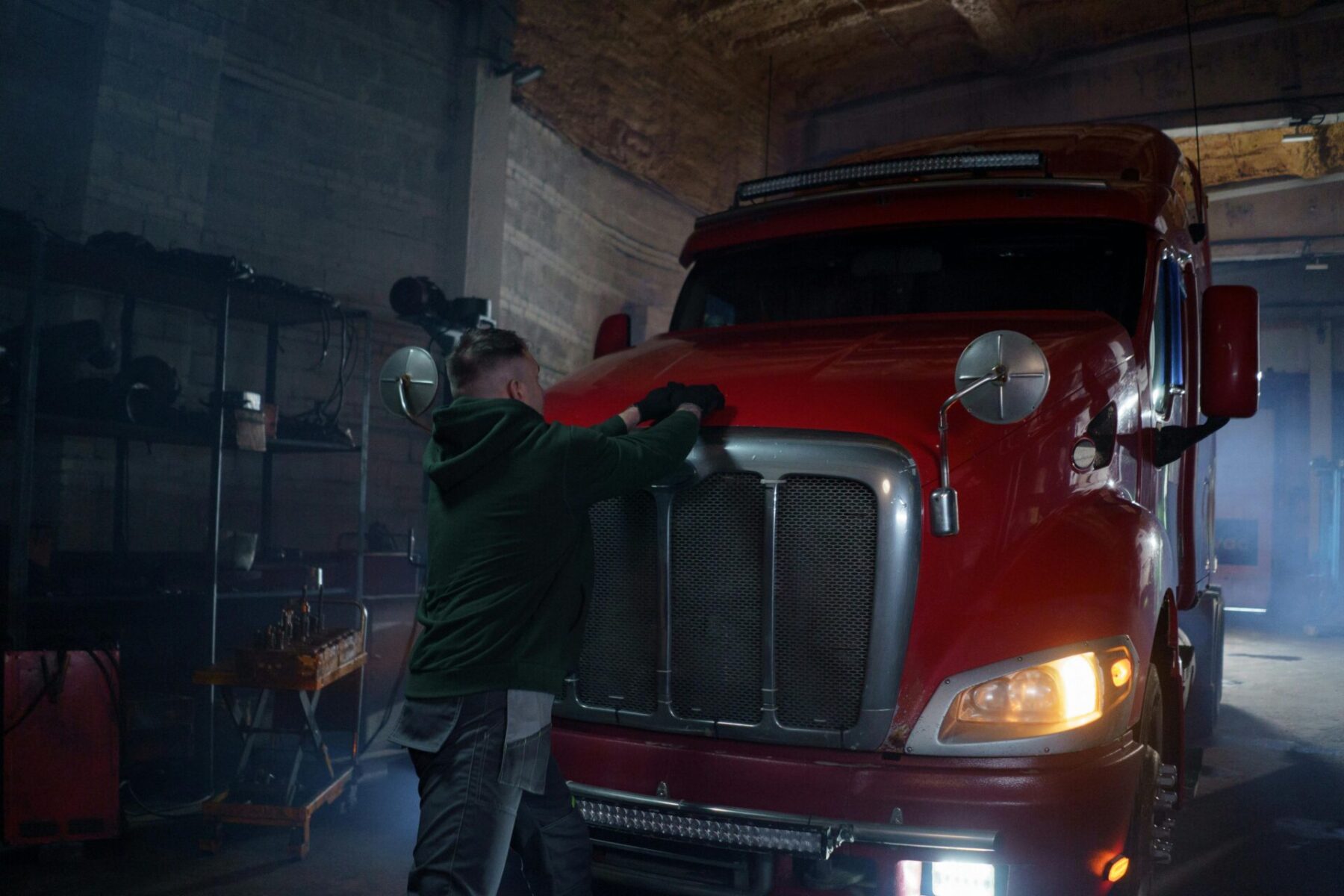A person inspecting a red 18-wheeler to determine fault in a truck accident