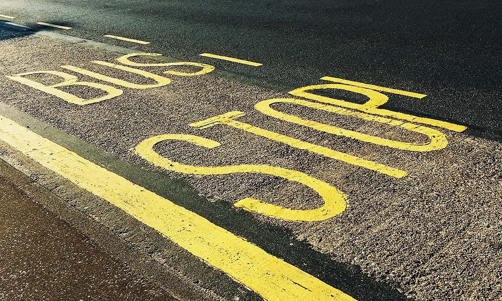 ‘Bus Stop’ painted in yellow on a road, which can help prevent school bus accident cases