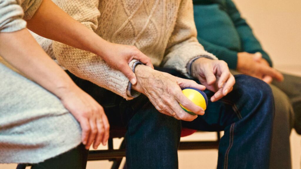 A senior citizen holding a ball