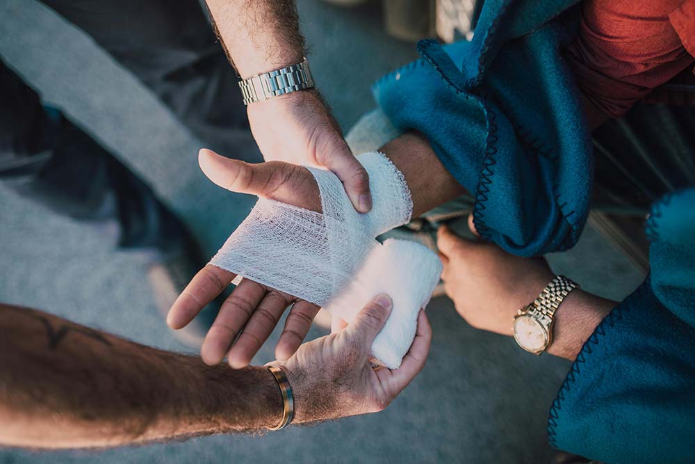 A paramedic bandages a burn victim’s hand