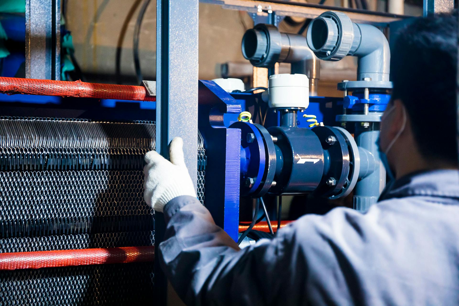 A worker inspecting industrial machinery inside a ZF Transmission Manufacturing facility, commonly referenced in ZF Transmissions Manufacturing workers’ compensation FAQs