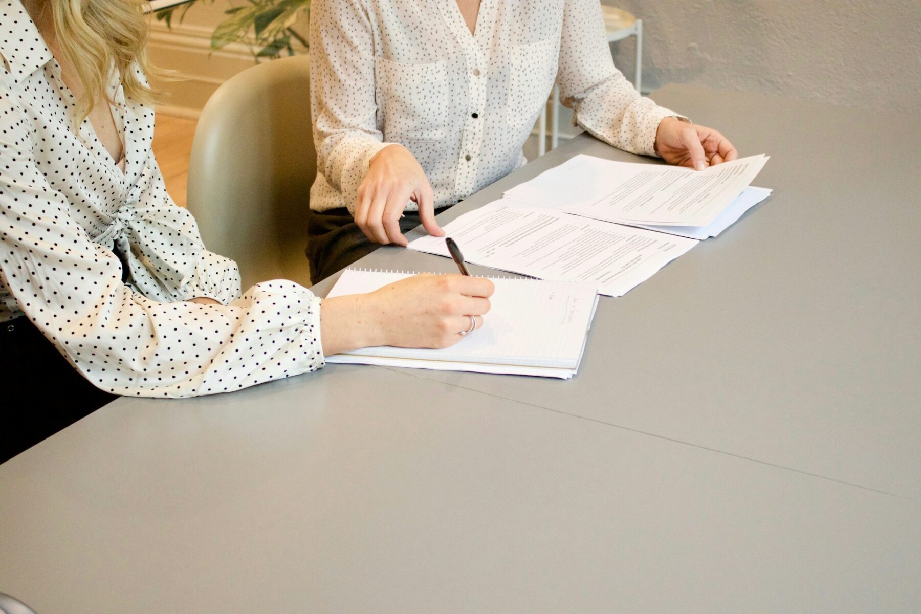 Two people sitting down and discussing criminal law questions and writing information down