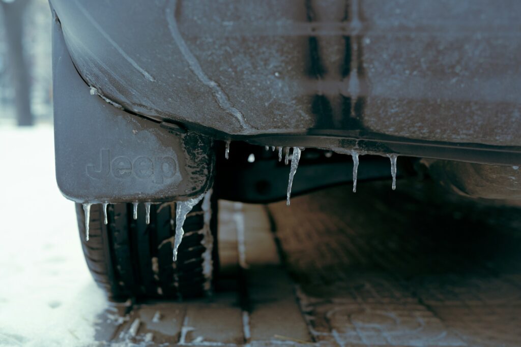 The underside of an automobile with icicles forming on it