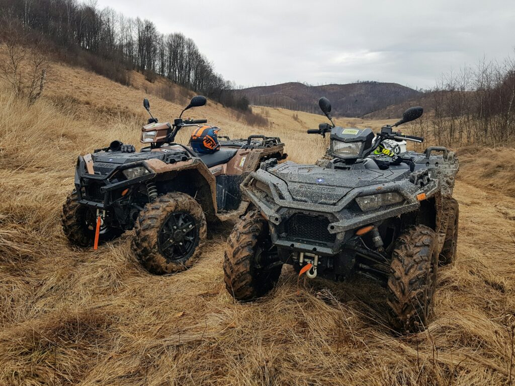 Two ATVs parked side-by-side in a field