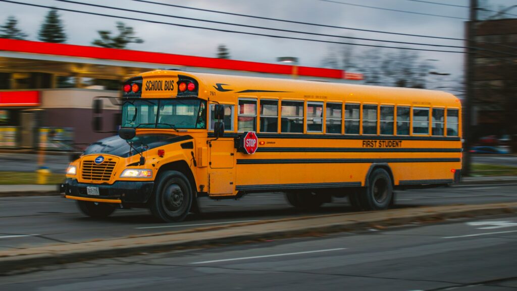 A yellow school bus moving down a street
