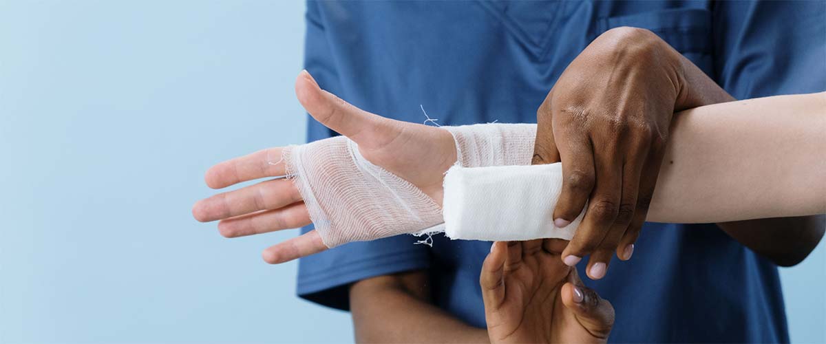 A medical professional bandaging a patient’s injured hand, a type of case handled by Charleston personal injury attorneys